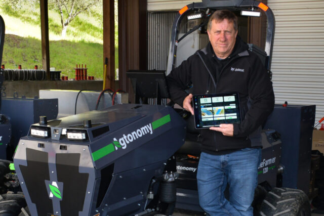 Entrepreneur and farmer Tim Bucher with Agtonomy's all-electric tractor and TeleFarmer Service app [Photo by Leigh Wachter, courtesy of Agtonomy]